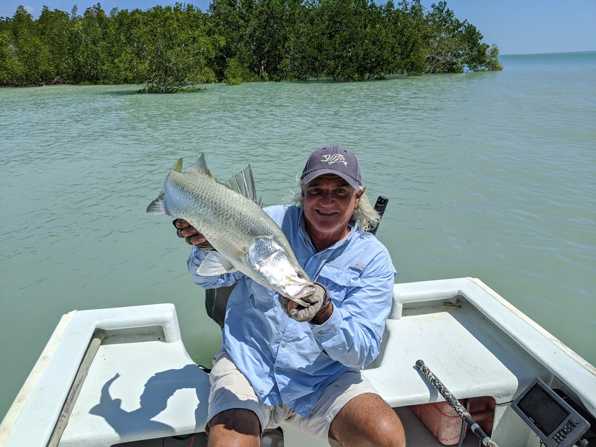 Captain Dan holding a fish on the back of his Tender boat