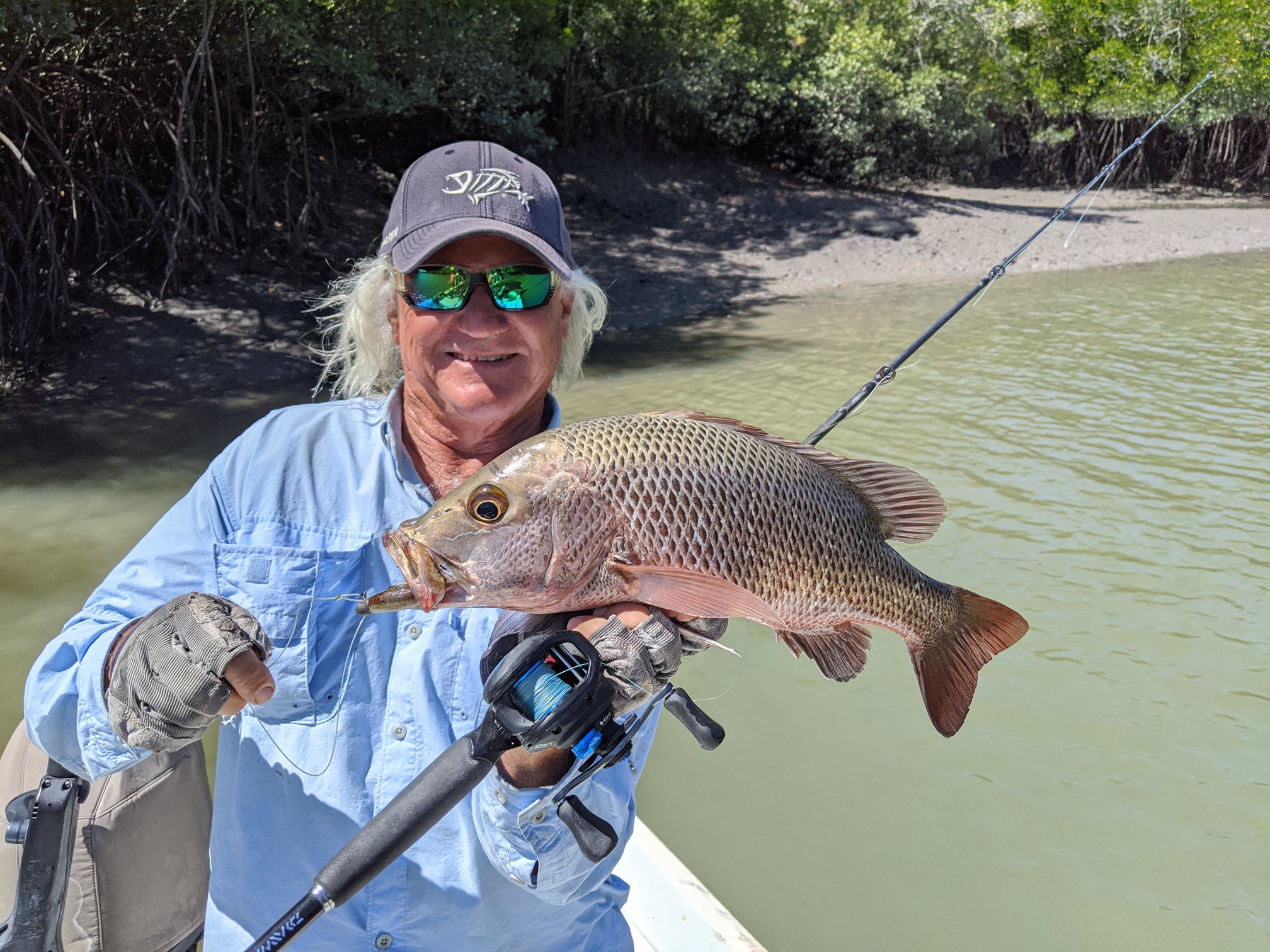Captain Dan with rod and fish in an Arnhem Land estuary