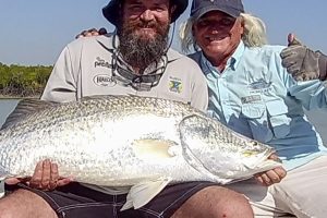 Captain Dan posing with fisherman and his large barra catch NT